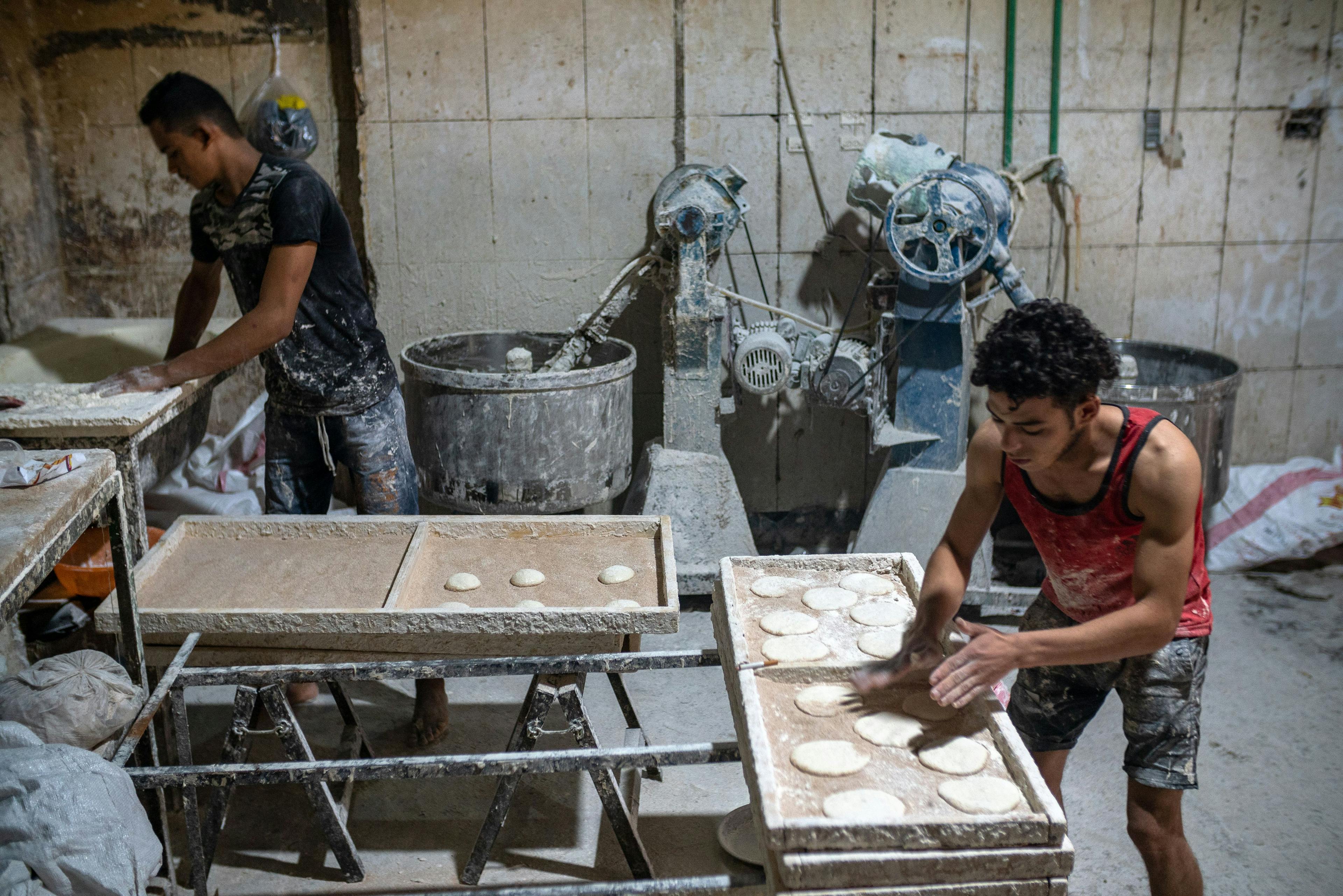 Hassan Gabr Ahmed (front) and Taha El-Seidie (back) moved from a village in the Sohag region along the Nile River, and now work in this downtown bakery. Millions of Africans will make the rural-urban trek, despite cities’ climate risks.