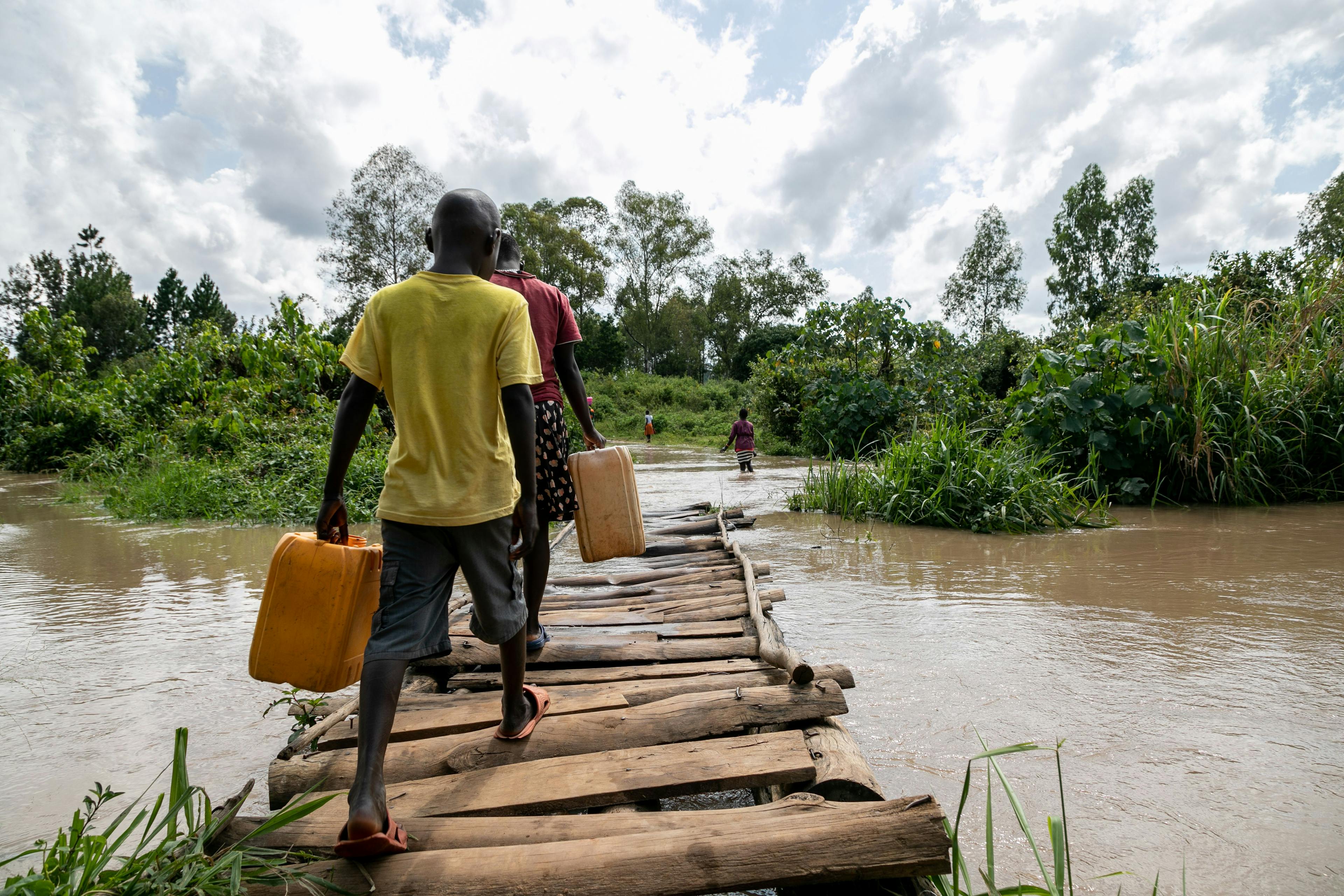 A temporary bridge allows foot traffic to cross the river after the original was washed away. Border areas often receive less support than capital cities. They need local cooperative solutions as climate mobility boosts cross-border connections. 