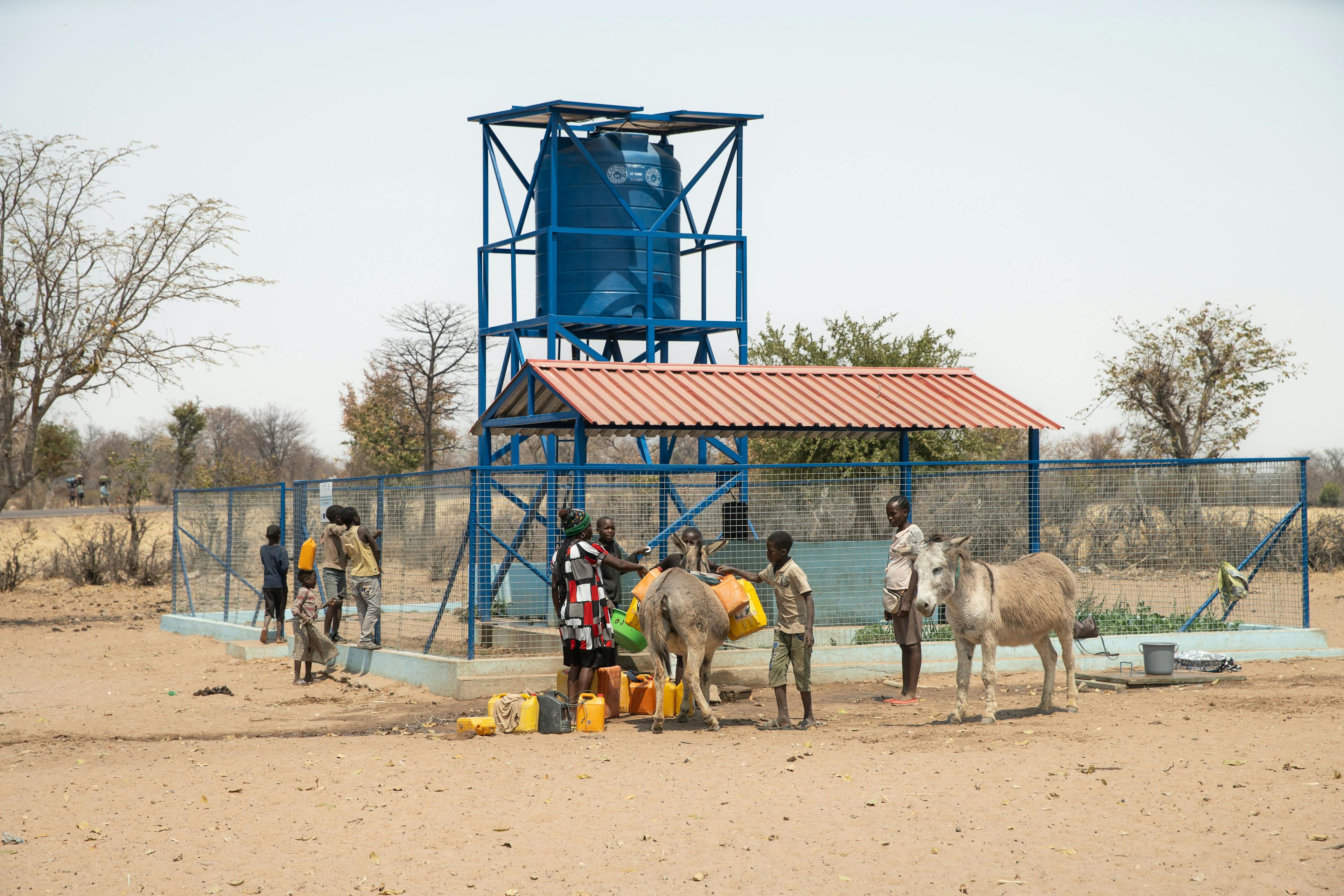 People collect drinking water from storage tanks near a borehole. Africa will need to find cooperative solutions for land and water management to offset climate stressors, and reduce the risk and the impacts of displacement.